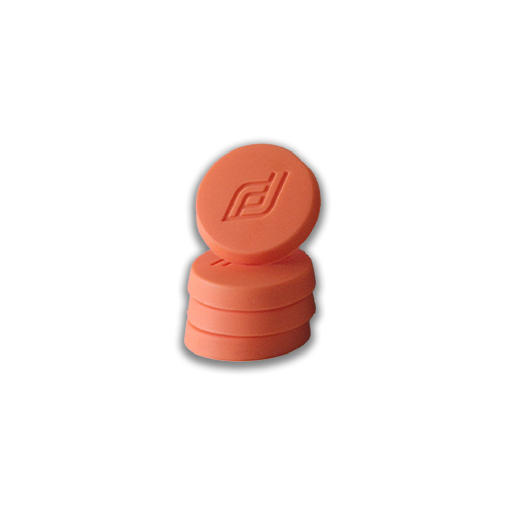 Stack of orange rubber bottle stoppers with an embossed logo on the top stopper